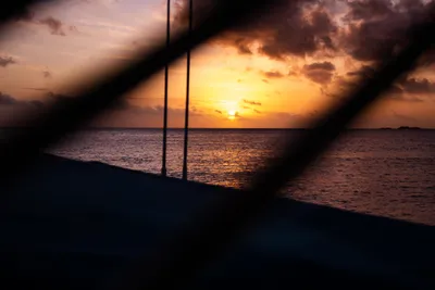 A breathtaking sunset over the Whitsunday Islands, with a calm sea horizon.